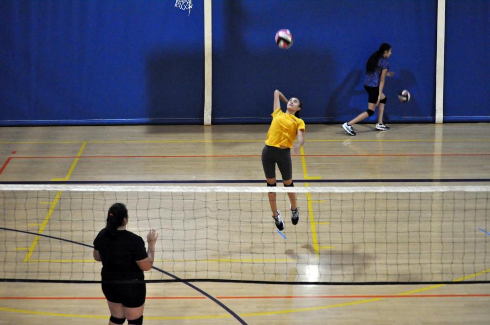 Volleyball players hitting a play indoors