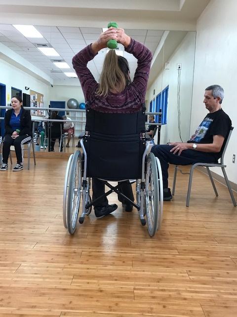 Woman in wheelchair exercising