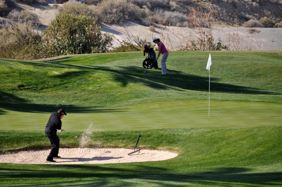 Golfer chips from the sand trap