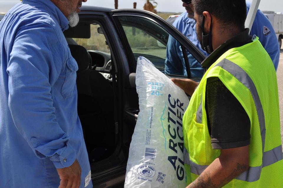 Men loading bag of ice into car