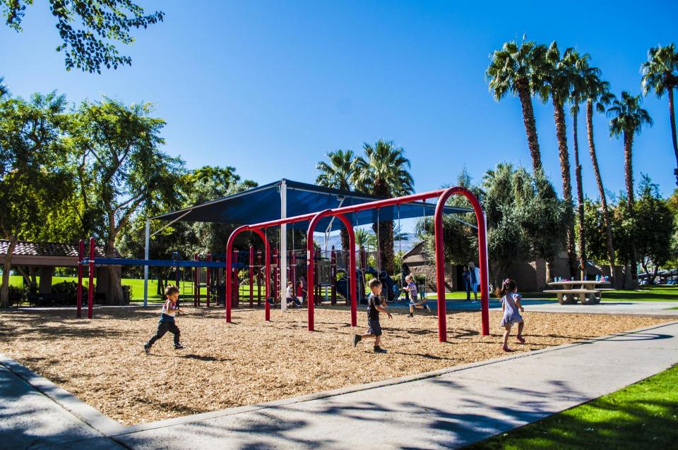 Photo of kids playing near the swings at the playground