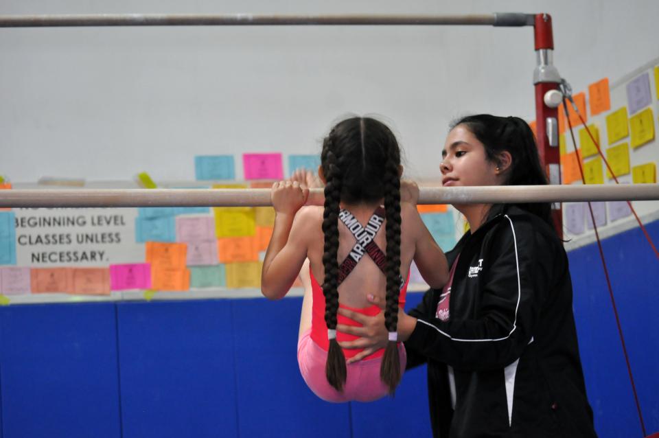 One female gymnast with instructor