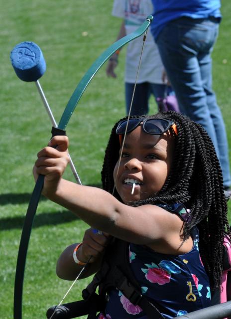Girl in wheelchair shooting an arrow with a bow