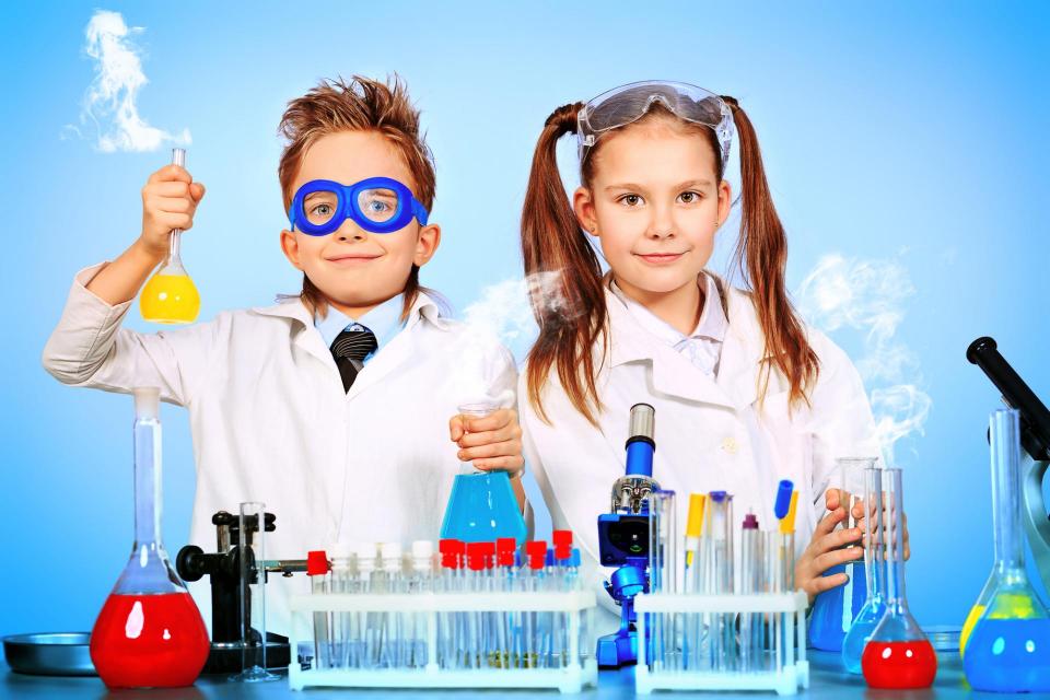 Boy and girl doing science experiments in white lab coats