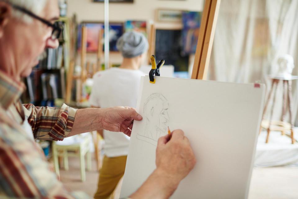 Senior man drawing on an art pad
