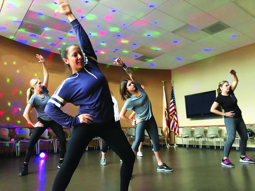 Four people working out in group fitness class indoors
