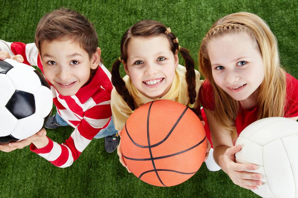 Youth holding various sports balls