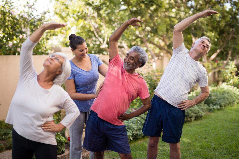 Teacher with several adult students stretching in a park