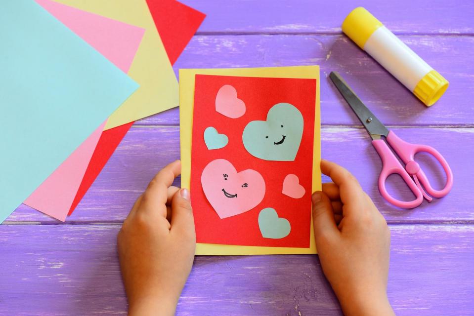Child's hands holding home made valentine card