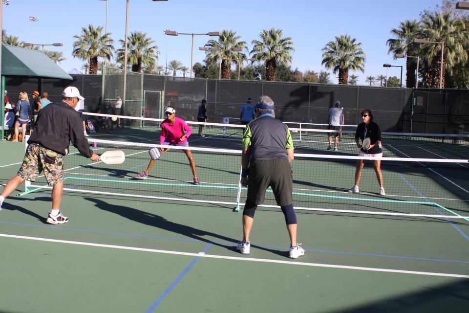 Photo of people playing pickleball outdoors