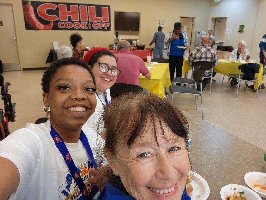 Two ladies in front of Chili Cook off banner