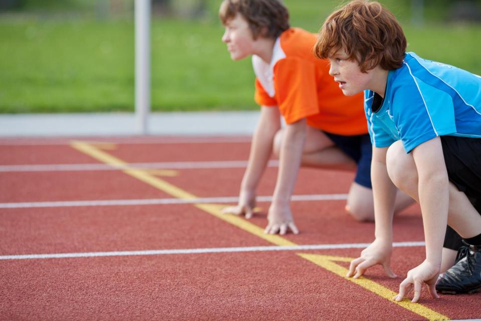 Youth runners at the start line of a running track