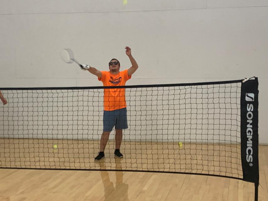 Adult man playing badminton indoors