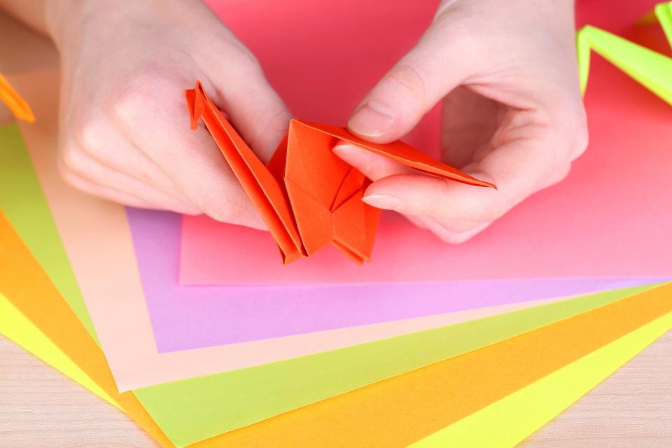 Hands folding paper for origami