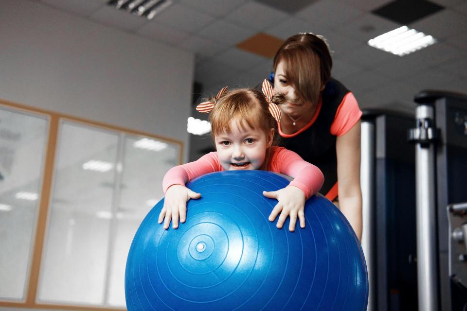 Toddler with an adult on an exercise ball