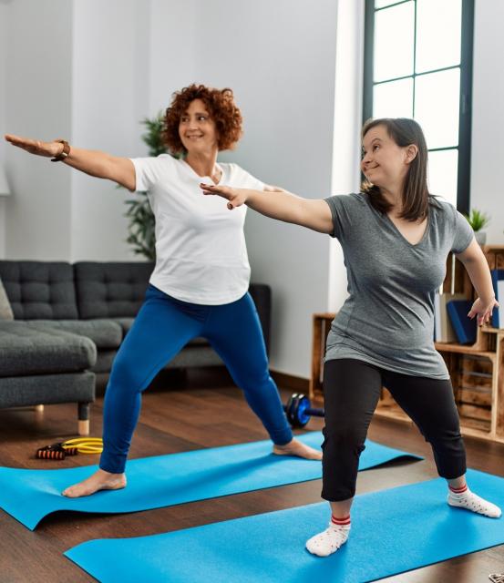 Two people stretching n Yoga type of movement
