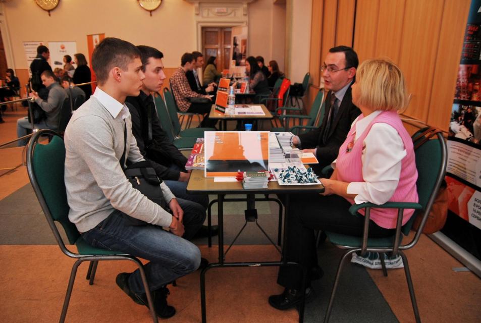 Employers at a table discussing job openings with youth