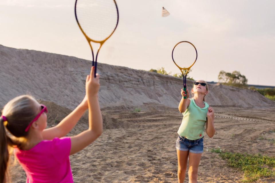 Two female teens playing badminton