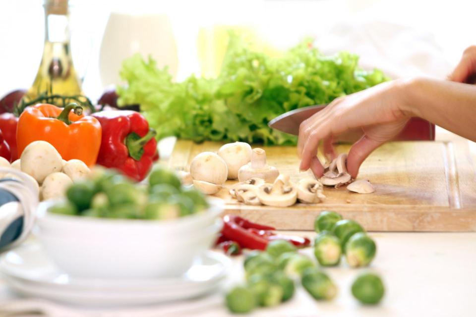 Fresh vegetables with a hand shown chopping