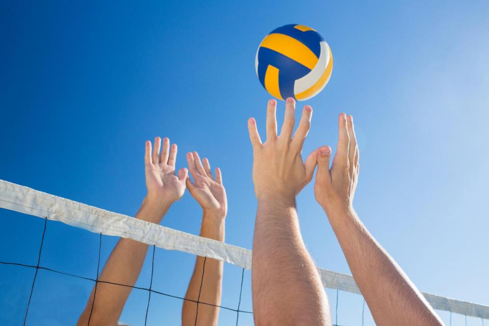 Hands reaching for volleyball