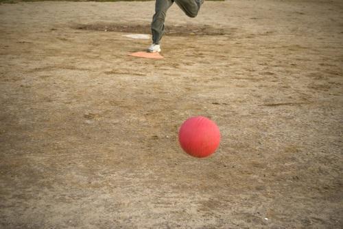 Person's legs running toward a kickball