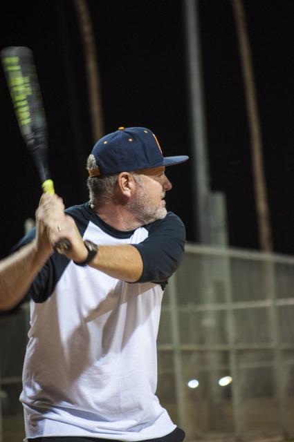 Adult swinging a bat in softball