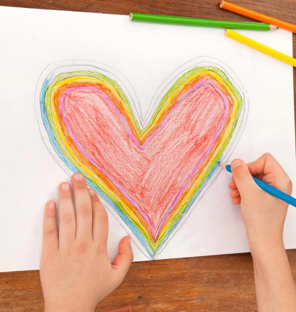 Close up of child's hands coloring in a Valentine's Day Hart