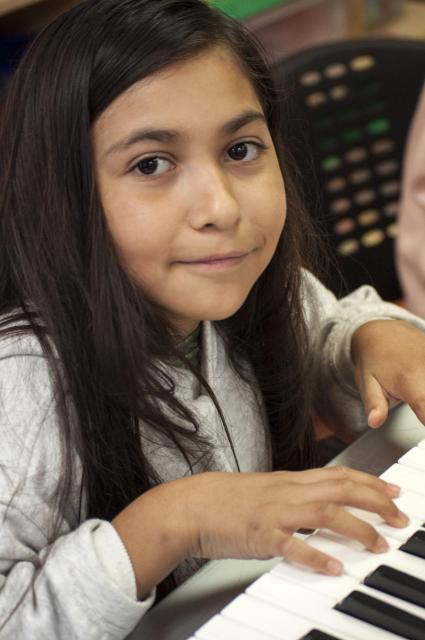 Girl learning to play piano