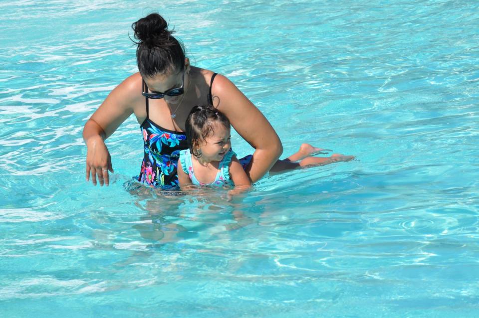 Mother teaching infant to swim in pool