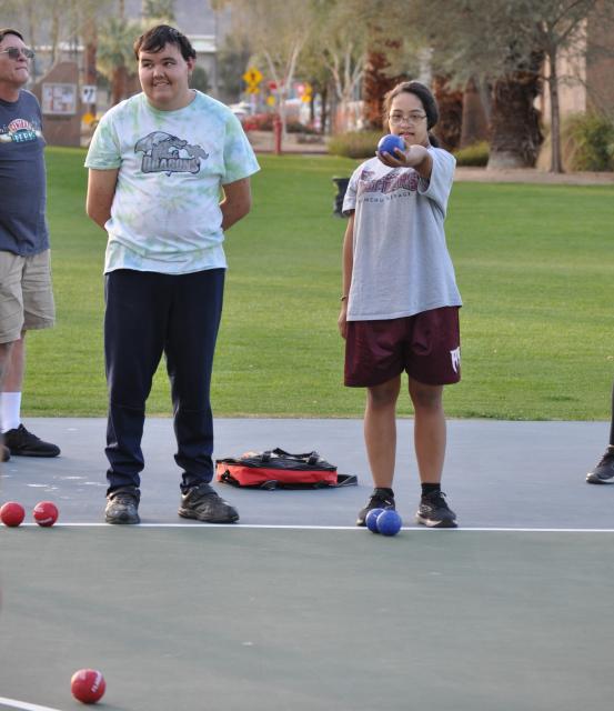 Two people playing bocce ball