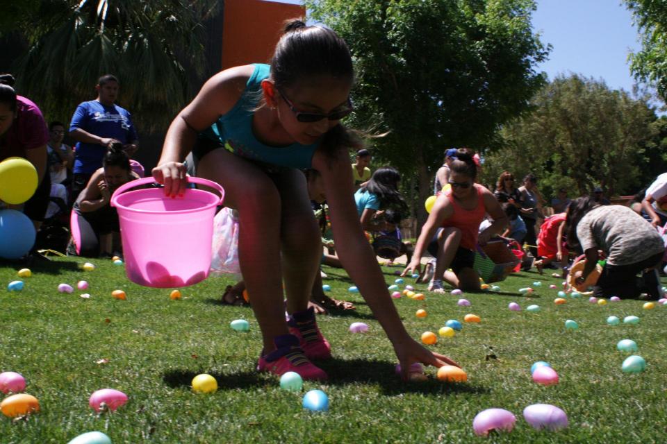 Person picking up eggs during Easter egg hunt