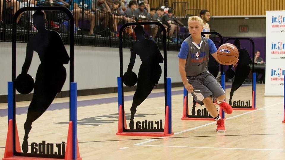 Photo of boy on indoor basketball court dribbling the ball