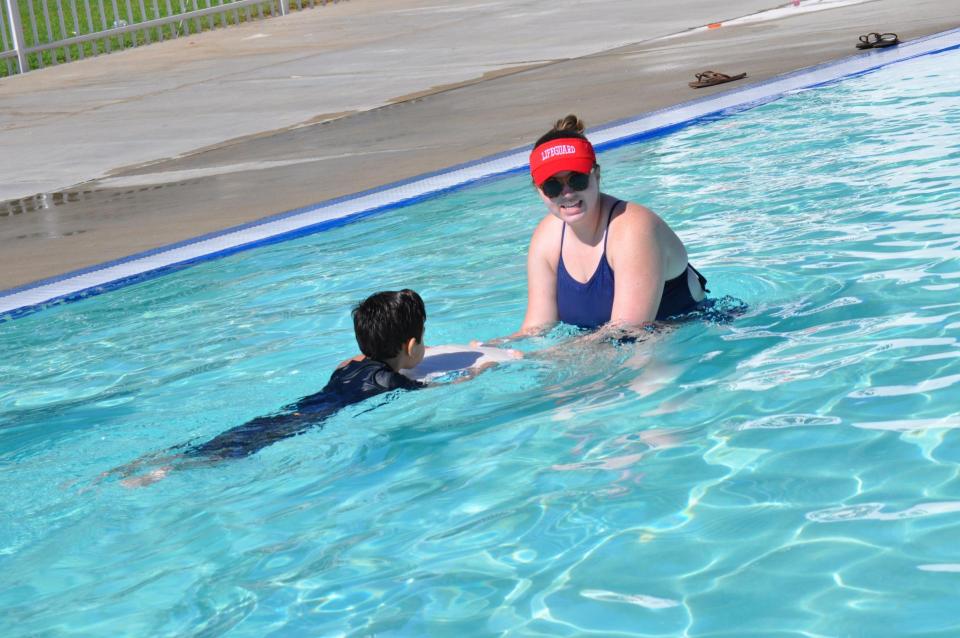 Swim instructor with preschool aged child in pool
