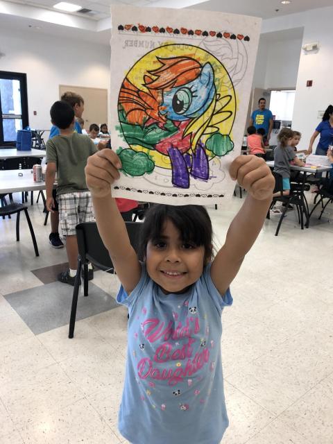 Little girl holding up a painting